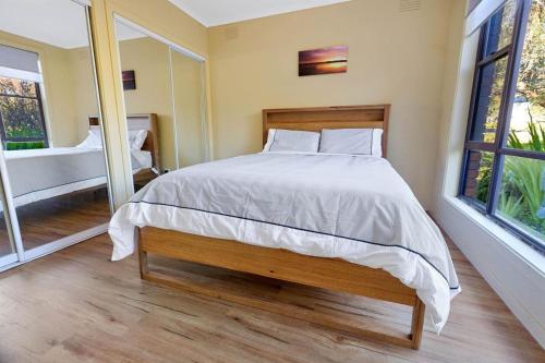 a bedroom with a large bed and two windows at Above Sunset in Paynesville