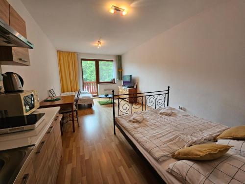 a bedroom with a large bed and a kitchen at Fatrapark 1 Apartments in Ružomberok