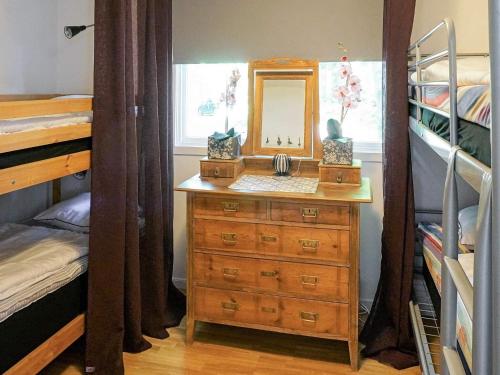 a bedroom with a dresser with a mirror and bunk beds at 8 person holiday home in HYLTEBRUK in Hyltebruk