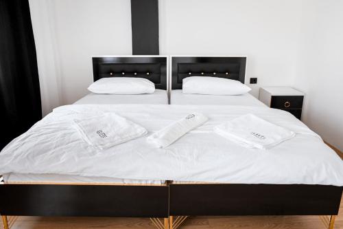 a bed with two white towels on top of it at Elitte in Kavadarci