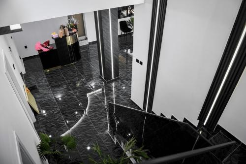 a hallway with a black tile floor and a staircase at Elitte in Kavadarci