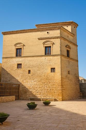 a large brick building with three windows on it at Barbacana, dieciocho in Baeza