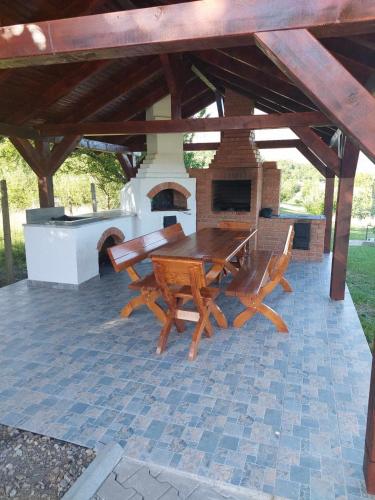 a picnic table and chairs on a patio with a fireplace at Cabana Gap House in Colţeşti