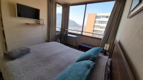 サンティアゴにあるApartamento Pet-Friendly, Piscina, Vista Cerro San Cristobal, Santiagoのベッドと大きな窓があるホテルの部屋
