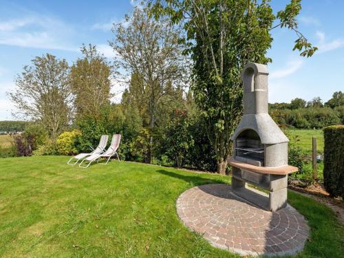 a stone oven in a yard with two chairs at Charming Nieuwpoort Mill Retreat in Zottegem