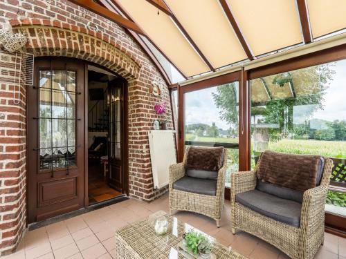 an outdoor patio with two chairs and a door at Charming Nieuwpoort Mill Retreat in Zottegem