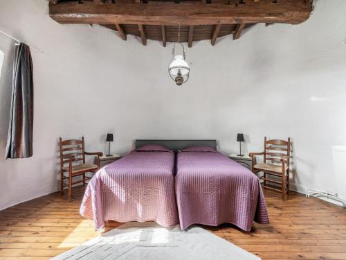 a bedroom with a bed with a purple blanket at Charming Nieuwpoort Mill Retreat in Zottegem
