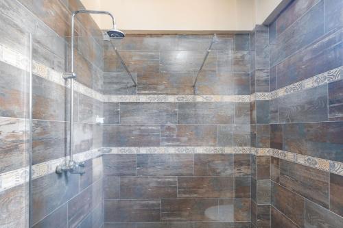 a bathroom with a shower with brown tiles at Ingoo Club in Dar es Salaam