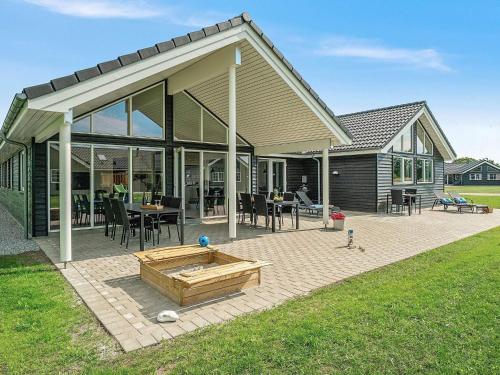 a house with a large patio with a wooden sandbox at 5 star holiday home in Grenaa in Grenå