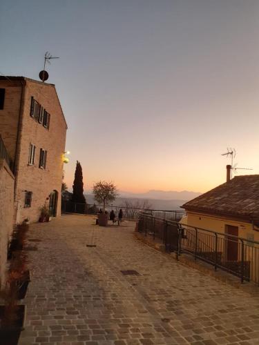 a street with buildings and a sunset in the background at Casa Lorenzetti in Recanati