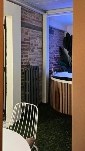 a room with a table and chairs and a brick wall at INsideOUT RELAX in Porto SantʼElpidio