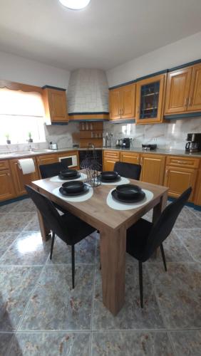 a kitchen with a wooden table and chairs at HOME sweet HOME in Kefalos