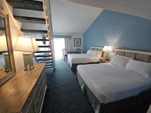 a hotel room with two beds and a staircase at Surf Side Hotel in Nags Head
