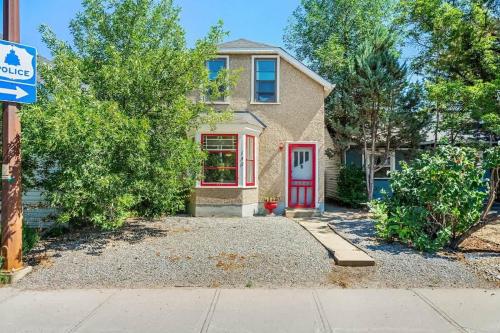 a house with a red door on a street at The Red Steps Away From World's Largest Dinosaur 3BR House in Drumheller