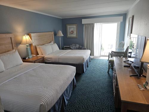 a hotel room with two beds and a television at Surf Side Hotel in Nags Head