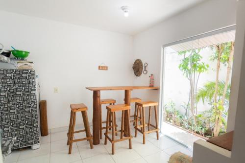a kitchen with a wooden table and stools at Pipa Guest House in Pipa