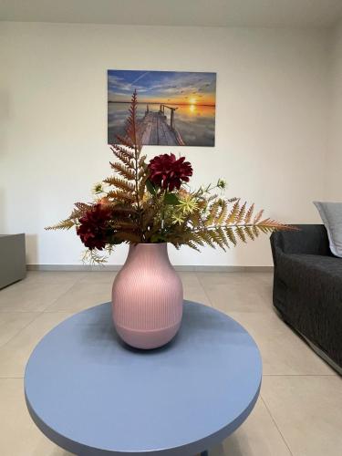 a pink vase with flowers on a table in a living room at Villa Primule Cattolica in Cattolica