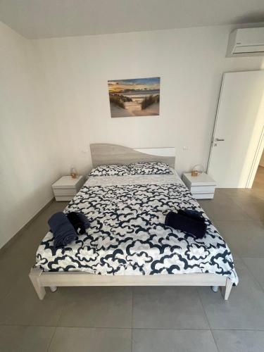 a bedroom with a bed with a black and white comforter at Villa Primule Cattolica in Cattolica