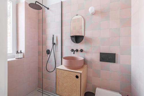 a pink bathroom with a sink and a shower at Adorján Apartments - Sunset Studio in Oradea