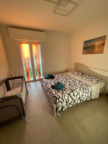 a bedroom with a bed and a chair and a window at Villa Primule Cattolica in Cattolica