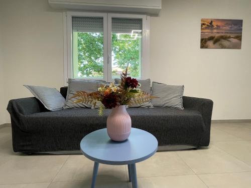 a living room with a couch and a vase on a table at Villa Primule Cattolica in Cattolica