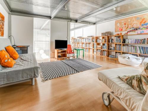 a living room with a couch and book shelves at Treehouse in Galicia near Silgar Beach in Sanxenxo
