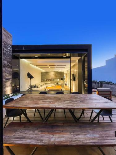 a large wooden table on the deck of a house at Rooftop & Private Pool Property Family in Guadalajara