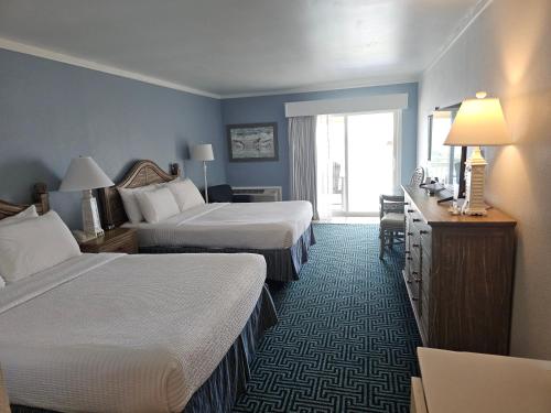 a hotel room with two beds and a desk at Surf Side Hotel in Nags Head