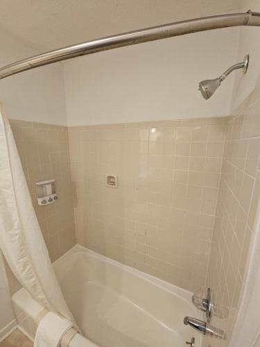 a bathroom with a bath tub with a shower at Surf Side Hotel in Nags Head