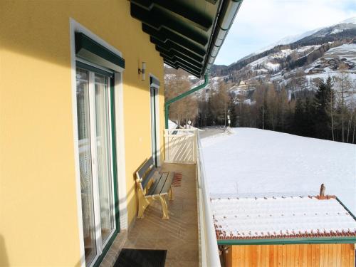 a balcony with a bench and a view of a snow covered mountain at Apartment in Katschberg near Ski Slopes in Rennweg