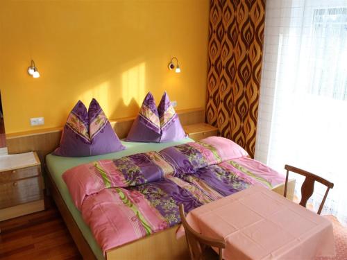 a bedroom with a bed with purple pillows at Apartment in Katschberg near Ski Slopes in Rennweg