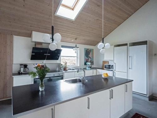 a kitchen with white cabinets and a black counter top at Luxury Retreat with Pool - By Traum Ferienwohnungen in Tisvildeleje