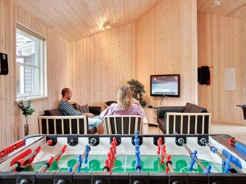 a group of people sitting in a room with a pool table at Luxury Retreat with Pool - By Traum Ferienwohnungen in Tisvildeleje