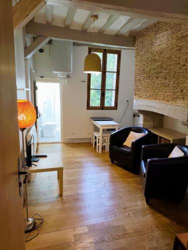 a living room with a couch and a table at Suite Duplex Vientiane - Second Lodge - Hyper Centre Historique Rennes - 2 personnes in Rennes