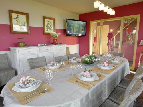a dining room with a long table with plates and glasses at Ovifat Sauna Escape, Waimes in Ovifat