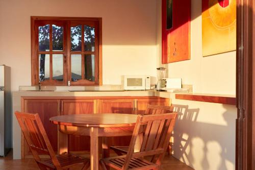 a kitchen with a table and chairs and a microwave at Hotel Albemarle Galapagos Beachfront in Puerto Villamil