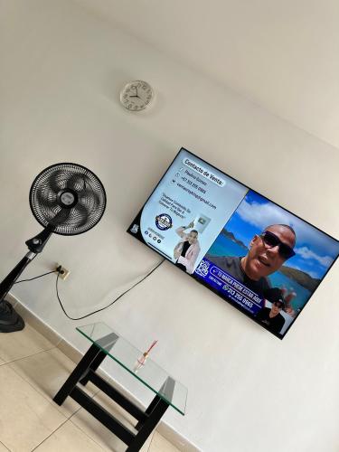 a sign on a wall with a table and a fan at Apartamentos La Ceiba in Valledupar