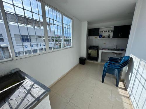 a kitchen with a blue chair in a room at Apartamentos La Ceiba in Valledupar