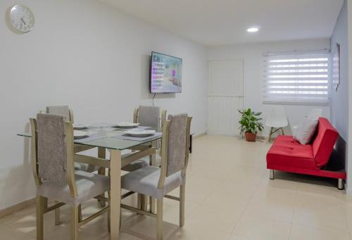 a dining room with a table and chairs and a red couch at Apartamentos La Ceiba in Valledupar
