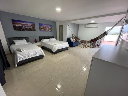 a room with two beds and a hammock in it at Apartamentos La Ceiba in Valledupar