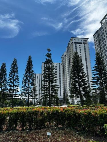 a group of tall buildings with trees in a park at Skye Studio in Kaybagal