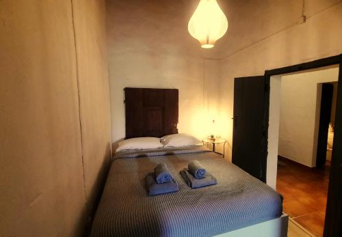 a small bedroom with a bed with blue towels on it at Casa dos Vizinhos - Casas de Taipa in São Pedro do Corval