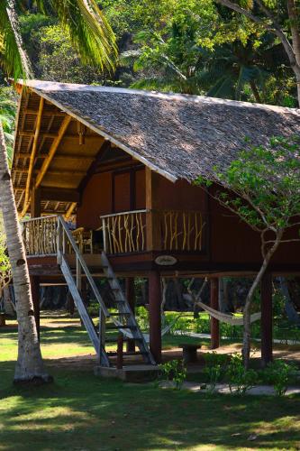 a house with a staircase leading to a porch at Sangat Island Dive Resort in Coron