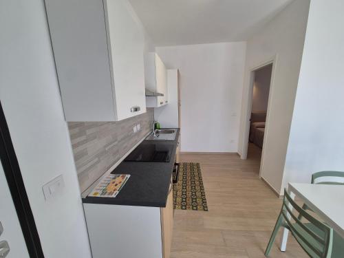 a kitchen with white cabinets and a black counter top at The Sun 365 - Sea View Apartment in Portopalo