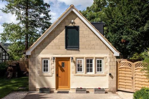 a small house with a brown door in a driveway at Abbey Rectory - with private parking in Bath