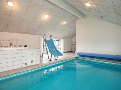 a swimming pool with a blue slide in a room at 14 person holiday home in Højslev in Sundstrup