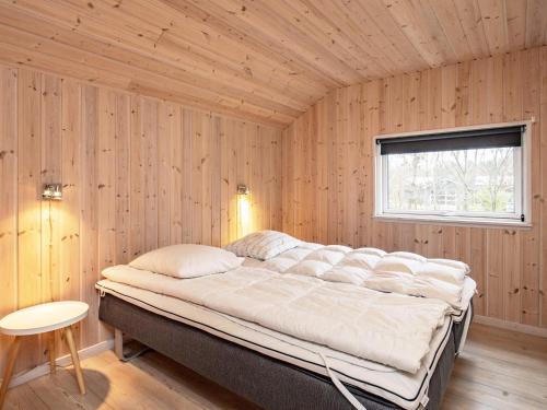 a bedroom with a large bed in a wooden wall at 14 person holiday home in Højslev in Sundstrup
