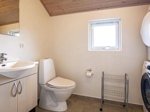 a bathroom with a toilet and a sink and a window at 14 person holiday home in Højslev in Sundstrup