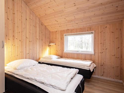 two beds in a room with a window at 14 person holiday home in Højslev in Sundstrup
