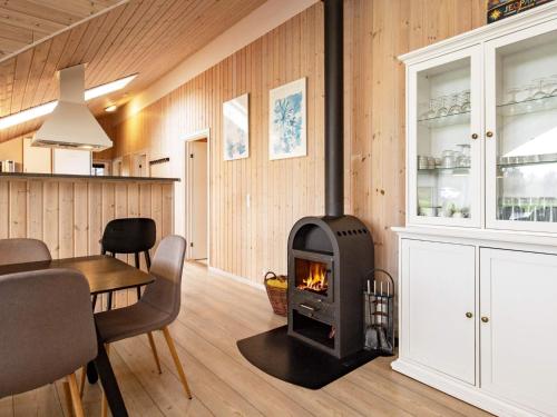 a fireplace in a living room with a table and chairs at 14 person holiday home in Højslev in Sundstrup